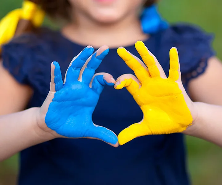Love Ukraine concept. Little girl show hands in heart form painted in Ukraine flag color - yellow and blue. Independence day of Ukraine, Flag, Constitution day Education, school, art painitng concept