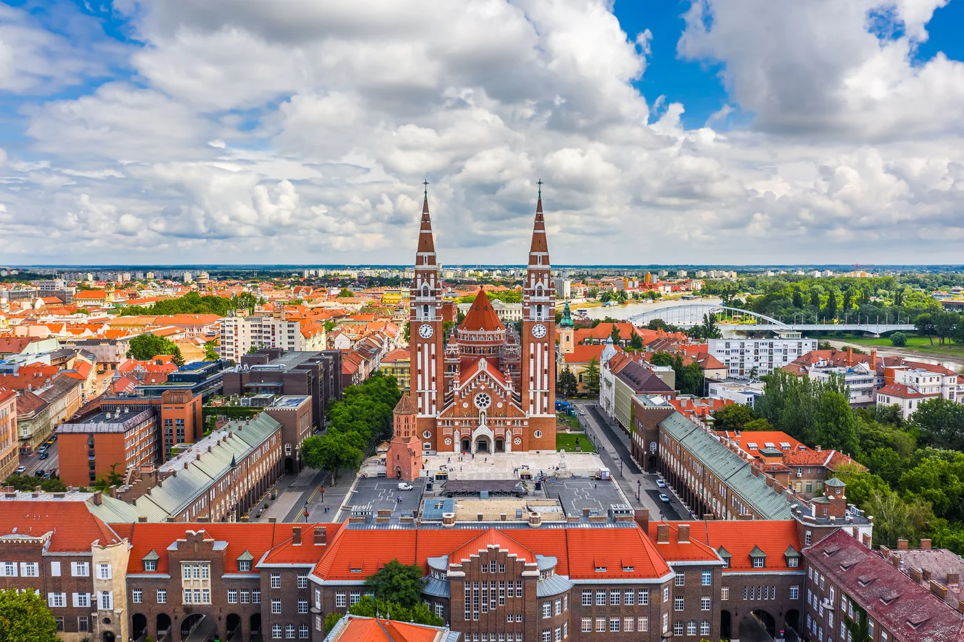 Szeged, Hungary - Aerial panoramic view of the Votive Church and Cathedral of Our Lady of Hungary (Szeged Dom) on a sunny summer day with Inner Town Bridge (Belvarosi hid) and blue sky and clouds