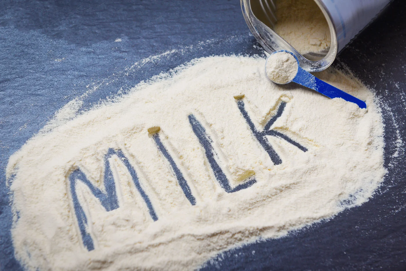Milk powder on dark background / powdered milk can , food healthy body from protein or for baby concept