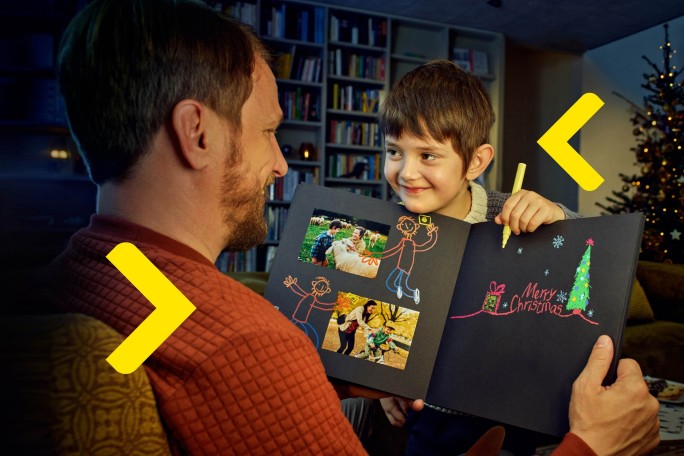 Child showing his father a christmas scrapbook