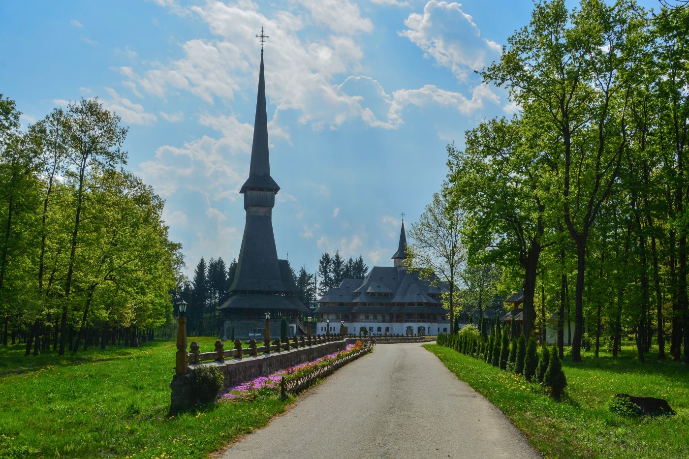 Sapanta Peri Monastery, Maramures, Romania, Europe, spring 2018. Traditional wooden church with the tallest bell tower in the world. Maximum height of 78 meters. Surrounded by vegetation.