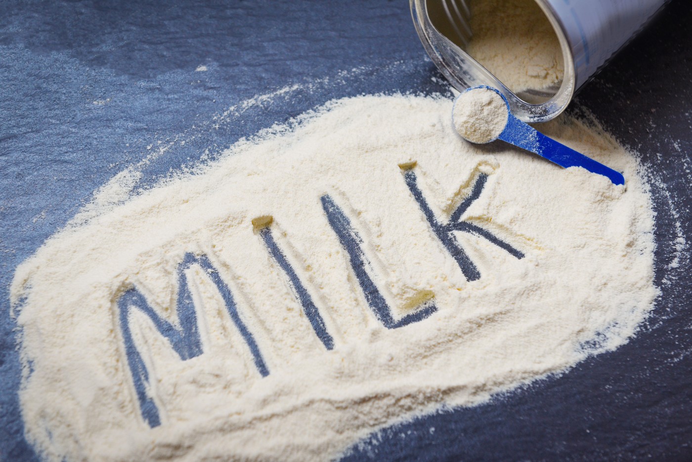 Milk powder on dark background / powdered milk can , food healthy body from protein or for baby concept