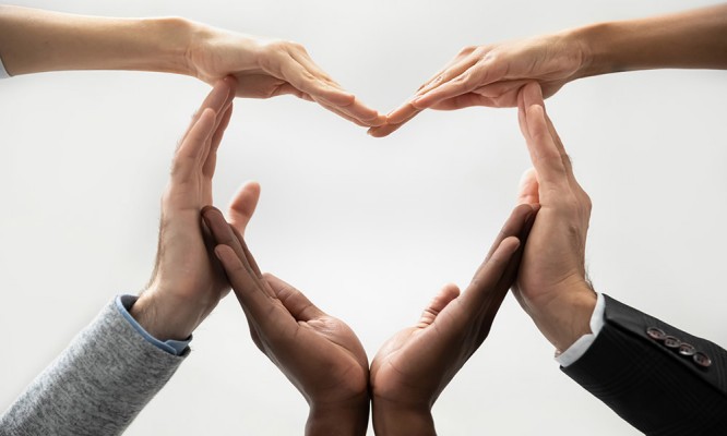 Concept of diverse business people join hands forming heart.